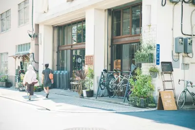 a woman walking down a street in front of a store at Nui. HOSTEL & BAR LOUNGE in Tokyo