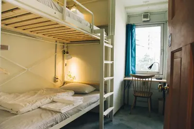a bedroom with two bunk beds and a desk at Nui. HOSTEL & BAR LOUNGE in Tokyo