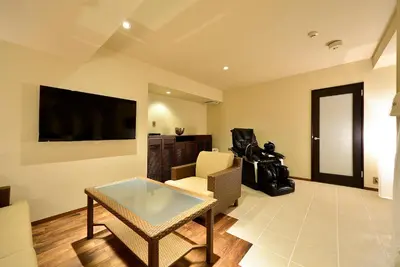 a living room with a table and a tv at AROMA+ (Adult Only) in Tokyo