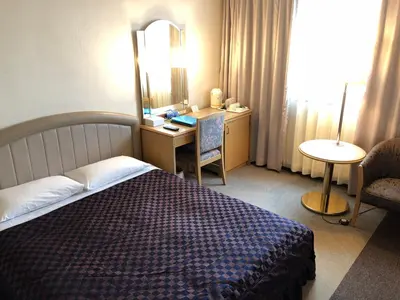 a bedroom with a bed and a desk and a mirror at Urayasu Beaufort Hotel in Urayasu