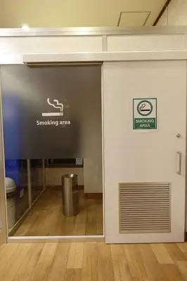 a sliding glass door with a smoking area sign on it at Urayasu Beaufort Hotel in Urayasu