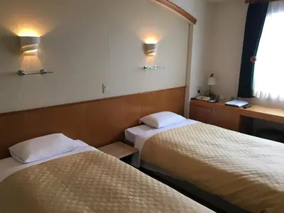 a hotel room with two beds and a window at Urayasu Beaufort Hotel in Urayasu