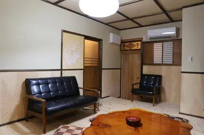 a living room with a couch and a chair at Kagaribi Guesthouse in Tokyo