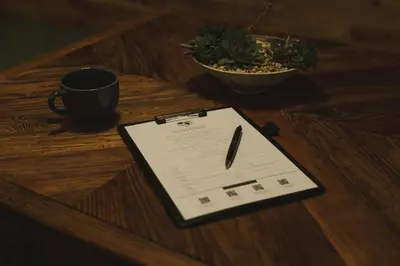 a clipboard on a table with a pen and a cup of coffee at DENCHI TOKYO - Private Designer Stay in Asakusa in Tokyo