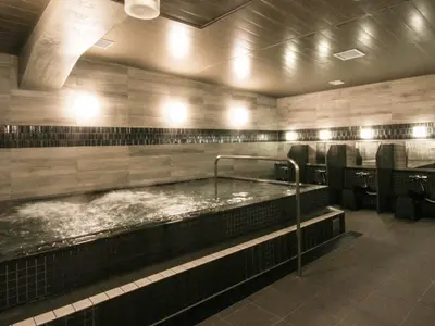 a bath room with a large tub with water at Gran Custama Ueno in Tokyo