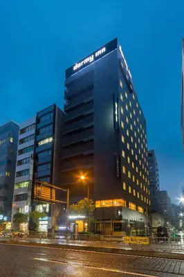 a building with a sign on the side of it at Dormy Inn Premium Tokyo Kodenmacho in Tokyo