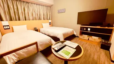 a hotel room with two beds and a flat screen tv at Dormy Inn Premium Tokyo Kodenmacho in Tokyo