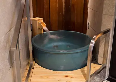 a large blue bath tub with a water fountain at Dormy Inn Premium Tokyo Kodenmacho in Tokyo