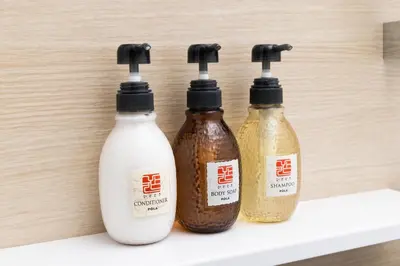 three bottles of sauce sitting on a shelf at Hotel Cerezo in Tokyo