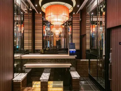 a lobby with a chandelier and benches in a building at APA Hotel Ginza Shintomicho Ekimae Kita in Tokyo