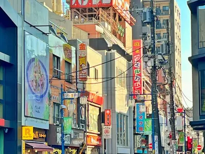 a busy city street with many signs on buildings at Edo Tokyo Hostel in Tokyo