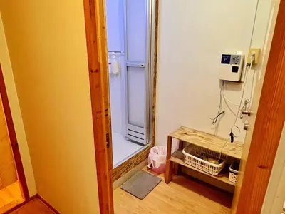 a bathroom with a refrigerator and a table with a mirror at Edo Tokyo Hostel in Tokyo