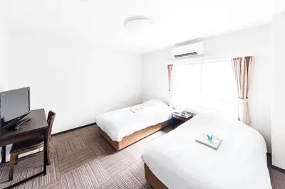 a hotel room with two beds and a desk at Best Hotel in Tokyo