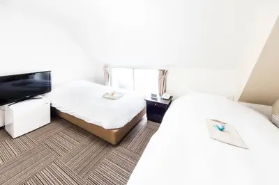 a hotel room with two beds and a flat screen tv at Best Hotel in Tokyo