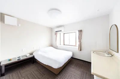 a small bedroom with a bed and a sink at Best Hotel in Tokyo