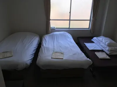 two beds in a small room with a window at Best Hotel in Tokyo