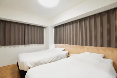 two beds in a hotel room with windows at Randor Residence Tokyo Classic in Tokyo