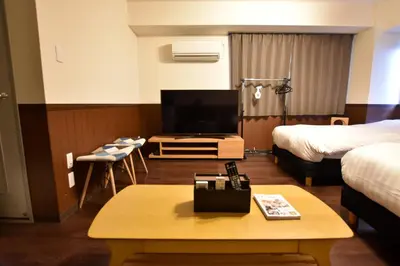 a hotel room with a tv and a bed and a table at Randor Residence Tokyo Classic in Tokyo