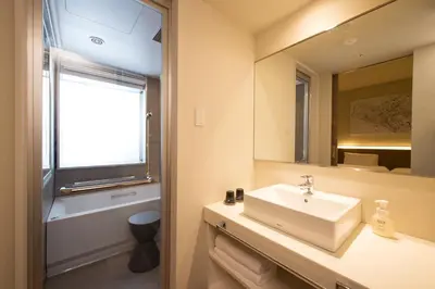 a bathroom with a sink and a mirror at remm Roppongi in Tokyo