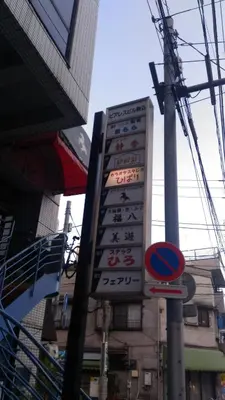 a large sign in front of a building with asian writing at Base Inn Komagome Tokyo in Tokyo