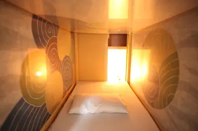 a small bed in a small room with a window at Base Inn Komagome Tokyo in Tokyo