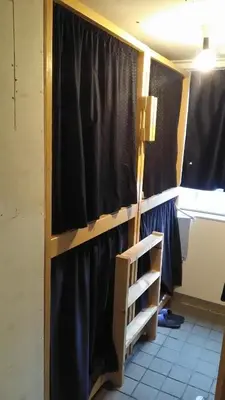 a room with a black curtain and a ladder at Base Inn Komagome Tokyo in Tokyo