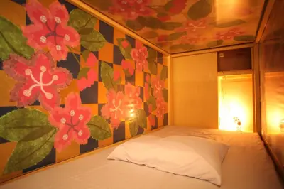 a bedroom with a flower patterned wall and a bed at Base Inn Komagome Tokyo in Tokyo