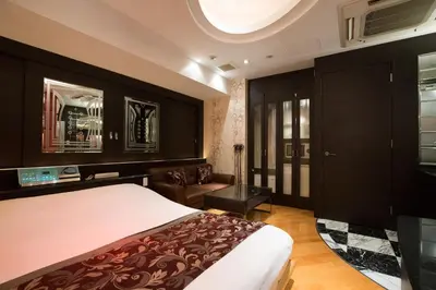 a bedroom with a large bed and a couch at HOTEL AN Shinjuku Kabukicho (Adult Only) in Tokyo