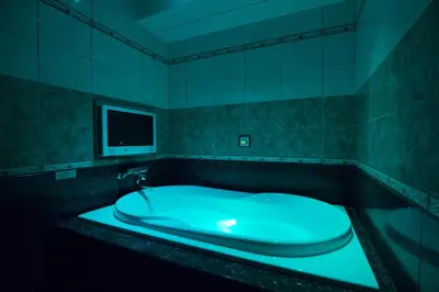 a bathroom with a green bath tub with a tv at HOTEL AN Shinjuku Kabukicho (Adult Only) in Tokyo