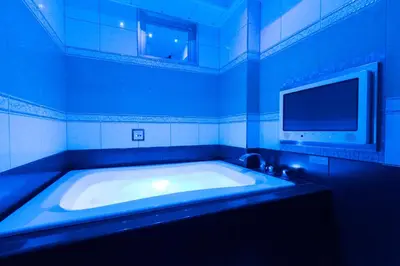 a blue bathroom with a large tub with a tv at HOTEL AN Shinjuku Kabukicho (Adult Only) in Tokyo