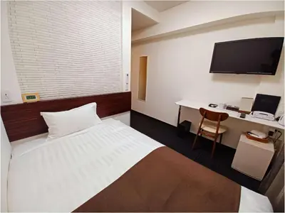 a bedroom with a bed and a desk with a computer at Akasaka Urban Hotel in Tokyo