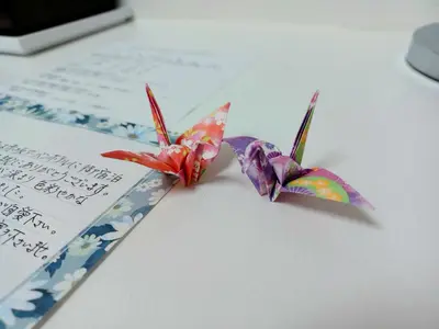 two origami birds sitting on top of a piece of paper at Akasaka Urban Hotel in Tokyo