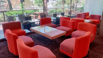 a waiting room with red chairs and a table at Day Nice Hotel Tokyo in Tokyo