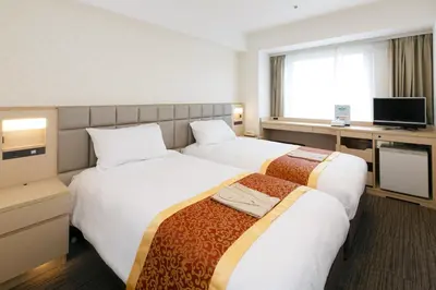 a hotel room with two beds and a television at Day Nice Hotel Tokyo in Tokyo