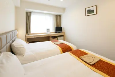 a hotel room with two beds and a desk at Day Nice Hotel Tokyo in Tokyo