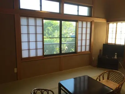 a room with a table and chairs and windows at Mokkoan in Tokyo