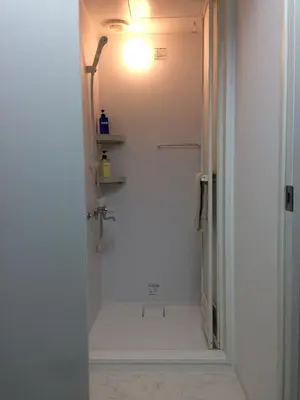 a bathroom with a shower with a light on the wall at Keys House in Tokyo
