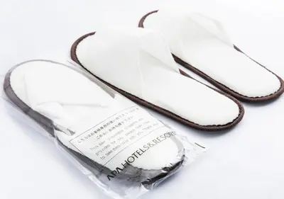 a pair of white flip flops in a plastic bag at APA Hotel TKP Nippori Ekimae in Tokyo
