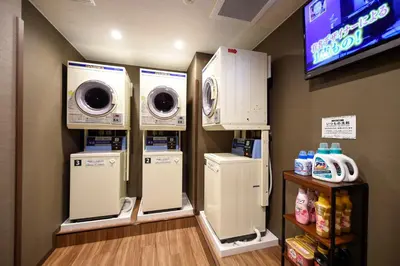 a laundry room with washers and dryers and a tv at Anshin oyado Tokyo Woman Ginza Shiodome in Tokyo