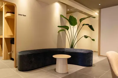 a black bench in a room with a potted plant at Hotel Paul House in Tokyo