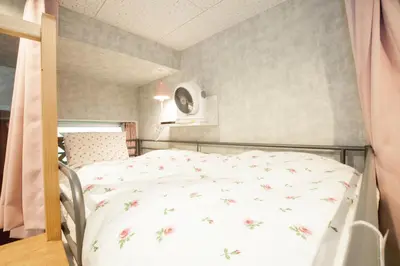 a bedroom with a bed with a floral bedspread at Akasaka-no Sato (Female Only) in Tokyo