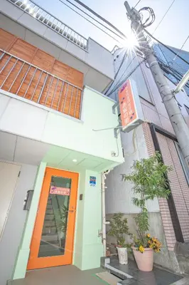 a building with an orange door and a plant at Akasaka-no Sato (Female Only) in Tokyo