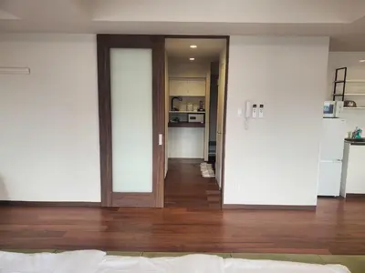 a bedroom with a door leading to a kitchen at City Pension Zem in Tokyo