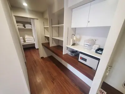 a kitchen with white cabinets and a hard wood floor at City Pension Zem in Tokyo