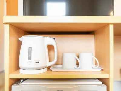 a coffee maker and two mugs in a cabinet at Super Hotel Ueno-Okachimachi in Tokyo
