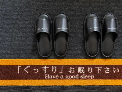 a pair of black shoes on top of a yellow stripe at Super Hotel Ueno-Okachimachi in Tokyo
