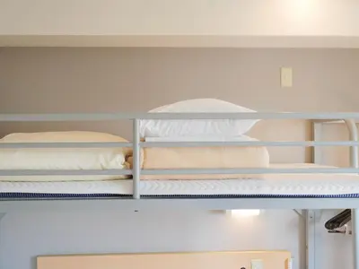 two bunk beds in a room with white walls at Super Hotel Ueno-Okachimachi in Tokyo