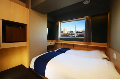 a bedroom with a large bed and a window at KOKO HOTEL Asakusa Komagata - formerly Hotel Wing International Select Asakusa Komagata in Tokyo