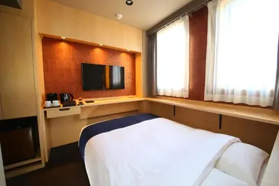 a small room with a bed and a television at KOKO HOTEL Asakusa Komagata - formerly Hotel Wing International Select Asakusa Komagata in Tokyo