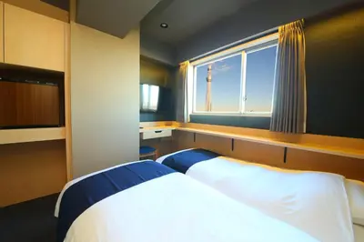 a bedroom with a large bed and a window at KOKO HOTEL Asakusa Komagata - formerly Hotel Wing International Select Asakusa Komagata in Tokyo